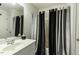 A bathroom featuring a vanity, mirror, and a shower with black and gray curtains at 9123 Thomas Rd, Rocky Mount, NC 27803