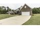 Brick two-story home featuring an attached garage and a long concrete driveway at 9123 Thomas Rd, Rocky Mount, NC 27803