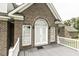 Brick front entrance with double front doors, white trim and grey deck and railings at 9123 Thomas Rd, Rocky Mount, NC 27803