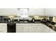 Charming kitchen offers black appliances, custom cabinetry, and recessed lighting at 9123 Thomas Rd, Rocky Mount, NC 27803
