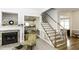 Charming living room showcasing a fireplace, staircase, and a glimpse into the kitchen at 9123 Thomas Rd, Rocky Mount, NC 27803