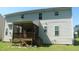 Home's rear exterior features a covered porch with stairs, vinyl siding, and several windows at 919 Middle Ground Ave, Rolesville, NC 27571
