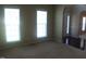 A carpeted room featuring a pair of large windows allowing natural light at 919 Middle Ground Ave, Rolesville, NC 27571