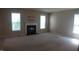 A carpeted room featuring a fireplace flanked by a pair of large windows allowing natural light at 919 Middle Ground Ave, Rolesville, NC 27571