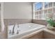 A luxurious garden tub is situated beneath a window with privacy blinds in the bathroom at 9639 Clubvalley Way, Raleigh, NC 27617
