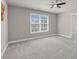Neutral bedroom featuring plush gray carpeting, a ceiling fan, and a bright window at 9639 Clubvalley Way, Raleigh, NC 27617