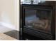 Close up of a sleek, modern gas fireplace with a glass front and black surround at 9639 Clubvalley Way, Raleigh, NC 27617