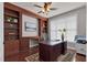 A home office with hardwood floors, built-in bookshelves, a ceiling fan, and a desk at 9639 Clubvalley Way, Raleigh, NC 27617