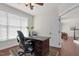 A well-lit home office with hardwood floors, a ceiling fan, and a view of the backyard at 9639 Clubvalley Way, Raleigh, NC 27617