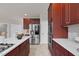 Modern kitchen with cherry wood cabinets, stainless steel appliances, island, and a view of the doorway at 9639 Clubvalley Way, Raleigh, NC 27617