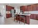 Kitchen island with a white countertop, dark cherry cabinetry, and seating for two at 9639 Clubvalley Way, Raleigh, NC 27617