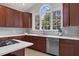 Bright kitchen with cherry wood cabinets, stainless steel appliances, stone backsplash, and a large arched window at 9639 Clubvalley Way, Raleigh, NC 27617