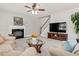 Comfortable living room with a fireplace, ceiling fan, and staircase access at 9639 Clubvalley Way, Raleigh, NC 27617