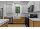 Kitchen boasts stainless steel appliances, white cabinetry, quartz countertop and black microwave at 100 Citrus Pl, Cary, NC 27519