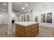 Open-concept living area with a kitchen island featuring wooden cabinetry and quartz countertops at 100 Citrus Pl, Cary, NC 27519