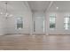 Spacious living room with gleaming wood floors, crown molding, ample windows, and elegant chandelier at 100 Citrus Pl, Cary, NC 27519