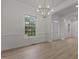 Bright living room featuring light wood flooring, a contemporary chandelier, and white trim at 100 Citrus Pl, Cary, NC 27519