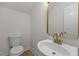 Stylish powder room with modern gold fixtures, bright white sink, and tiled floor at 100 Citrus Pl, Cary, NC 27519