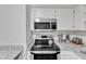 Bright kitchen showcasing granite counters, modern microwave, and sleek electric cooktop at 101 Oyster Bay Ct # B2, Cary, NC 27513