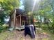 Exterior backyard view of the house in the woods with a wood porch and green yard at 103 N Woods Rd, Henderson, NC 27536