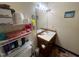 Cozy bathroom featuring a wooden vanity, sink, toilet and storage shelves at 103 N Woods Rd, Henderson, NC 27536
