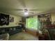 This living room includes a large window with natural light, a ceiling fan, and bookshelves at 103 N Woods Rd, Henderson, NC 27536