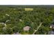 Expansive aerial view featuring a home surrounded by dense, mature trees and a glimpse of a large open field at 108 Ellsworth Pl, Chapel Hill, NC 27516