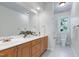 Bathroom with a double sink vanity, white tile floors, and a large mirror at 108 Ellsworth Pl, Chapel Hill, NC 27516