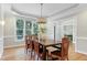 Dining area showcasing hardwood floors, a modern chandelier, and large windows at 108 Ellsworth Pl, Chapel Hill, NC 27516