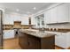 Well-lit kitchen boasts a central island, stainless appliances, and custom cabinets with stylish finishes at 108 Ellsworth Pl, Chapel Hill, NC 27516