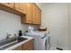 Well-organized laundry room featuring a sink, cabinetry, and modern washer and dryer at 108 Ellsworth Pl, Chapel Hill, NC 27516