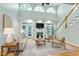 Bright living room with hardwood floors, fireplace, large windows, and staircase at 108 Ellsworth Pl, Chapel Hill, NC 27516