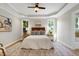 Bright main bedroom with a tray ceiling, two windows, and a ceiling fan at 108 Ellsworth Pl, Chapel Hill, NC 27516