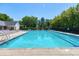 A large, inviting swimming pool with clear water and lounge chairs, surrounded by lush greenery at 108 Ellsworth Pl, Chapel Hill, NC 27516