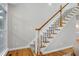 Carpeted staircase featuring wood banister and a bright, naturally lit landing at 108 Ellsworth Pl, Chapel Hill, NC 27516