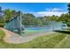 Fenced tennis courts with a green surface and blue lines, nestled in a green, wooded area at 108 Ellsworth Pl, Chapel Hill, NC 27516