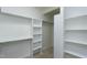 A walk-in closet featuring white shelving units, hanging rods, and neutral colored carpet at 108 Ellsworth Pl, Chapel Hill, NC 27516