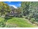 Expansive backyard with lush green lawn, mature trees, and a charming garden at 10909 Raven Rock Dr, Raleigh, NC 27614