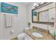 Well-lit bathroom with granite countertop, decorative mirror and fixtures, and complementing artwork at 10909 Raven Rock Dr, Raleigh, NC 27614