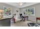 Bedroom features lots of natural light, a ceiling fan, desk, and an exercise bike at 10909 Raven Rock Dr, Raleigh, NC 27614