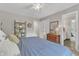 Comfortable bedroom with a ceiling fan, wood floors, shelf unit, and an ensuite bathroom at 10909 Raven Rock Dr, Raleigh, NC 27614