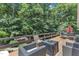 Outdoor living space on elevated deck with seating, firepit, and wooded views at 10909 Raven Rock Dr, Raleigh, NC 27614