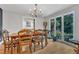 Dining room with hardwood floors, bright windows with greenery, and a view to another room at 10909 Raven Rock Dr, Raleigh, NC 27614
