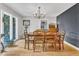 Bright dining room with hardwood floors, chandelier, and a large window offering natural light at 10909 Raven Rock Dr, Raleigh, NC 27614