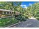 Exterior view featuring a well-maintained lawn, mature trees, and a charming brick home in a tranquil setting at 10909 Raven Rock Dr, Raleigh, NC 27614