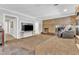 Open living area with exposed brick fireplace and adjacent wet bar, creating a seamless flow for relaxation and entertaining at 10909 Raven Rock Dr, Raleigh, NC 27614