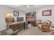 This well-lit office is complete with a large desk, hutch, and comfortable wicker chair, making it perfect for work at 10909 Raven Rock Dr, Raleigh, NC 27614