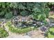 Aerial view of water feature pond surrounded by rocks and lush landscaping at 10909 Raven Rock Dr, Raleigh, NC 27614