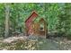 Rustic shed surrounded by trees with a convenient door, perfect for garden storage at 10909 Raven Rock Dr, Raleigh, NC 27614