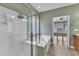 Bathroom with a glass-enclosed shower and separate soaking tub, leading to a bright bedroom at 113 Dowington Ln, Cary, NC 27519
